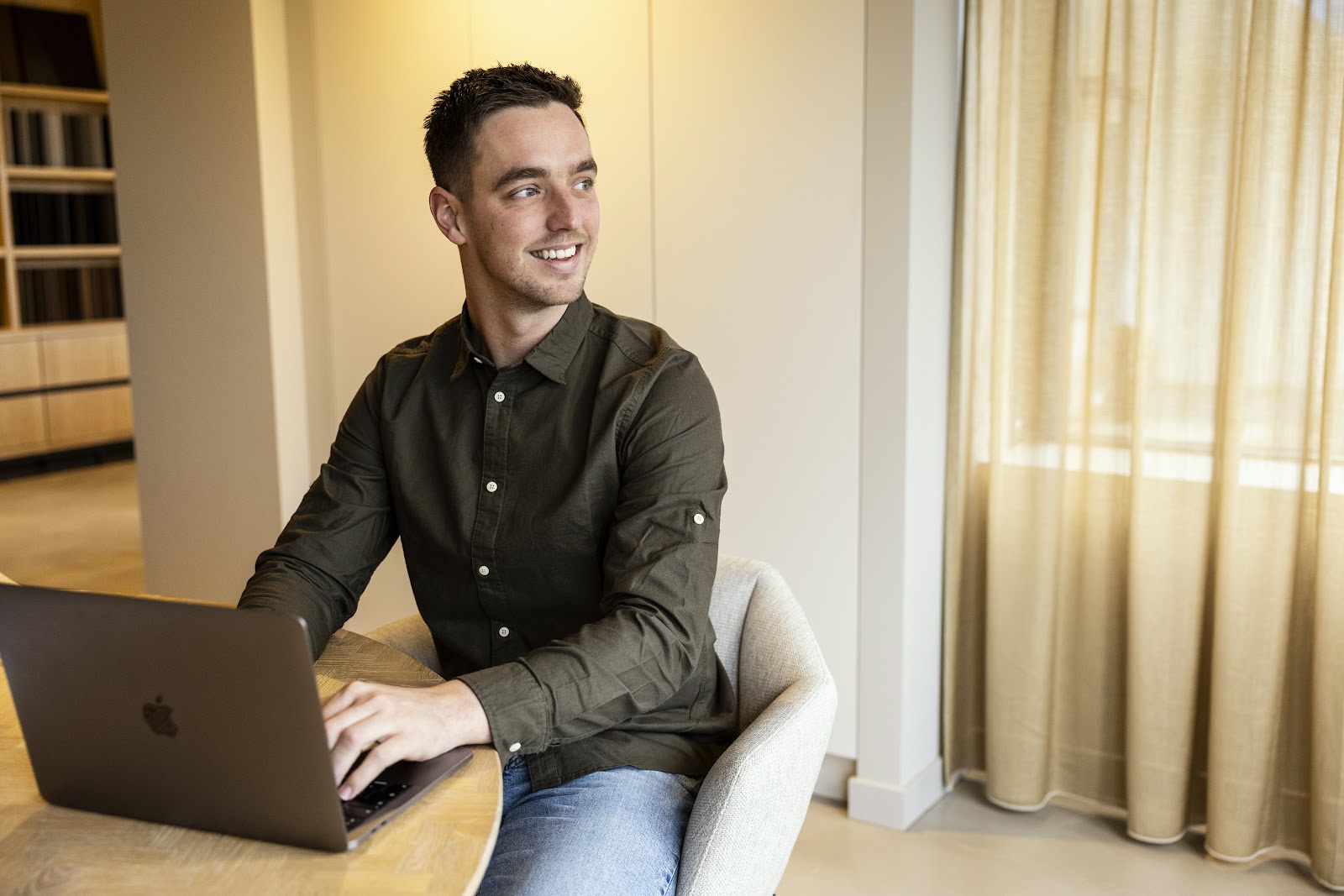 Collega van MarketingBuddy werkt aan tafel op zijn laptop
