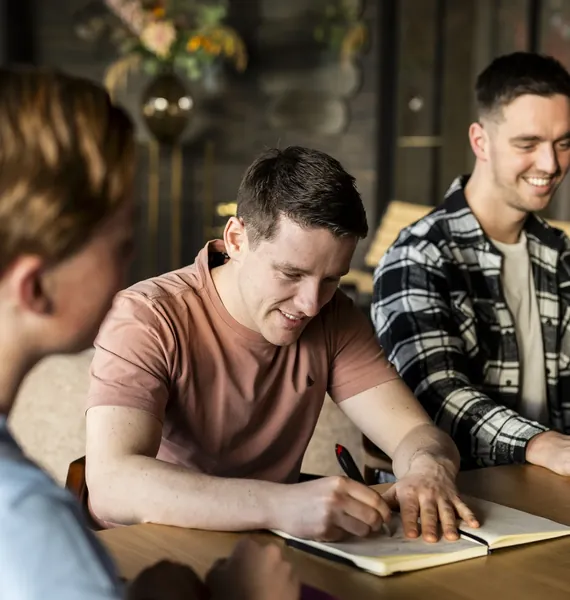 Collega schrijft aantekeningen tijdens een overleg