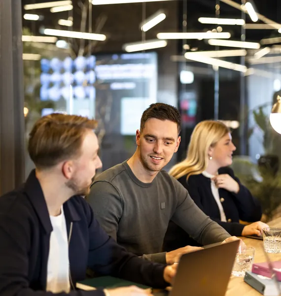 Drie collega's aan tafel met een laptop