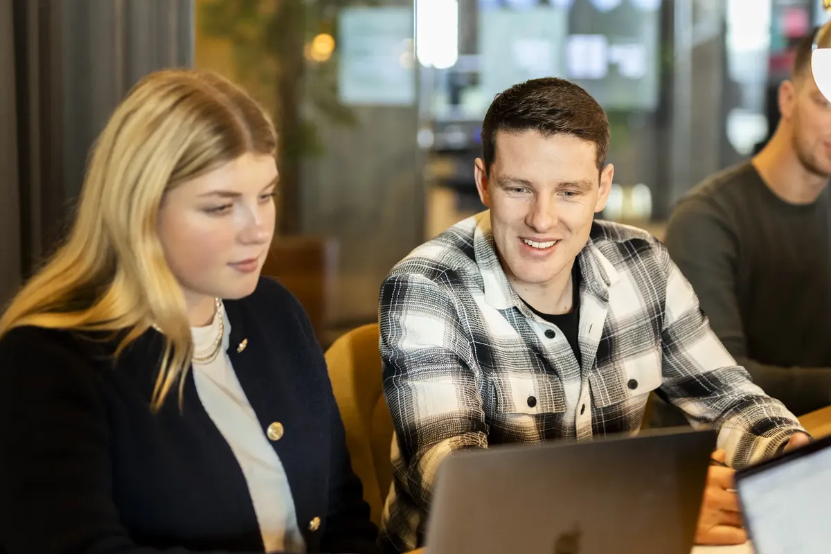 Twee collega's kijken samen naar een laptopscherm