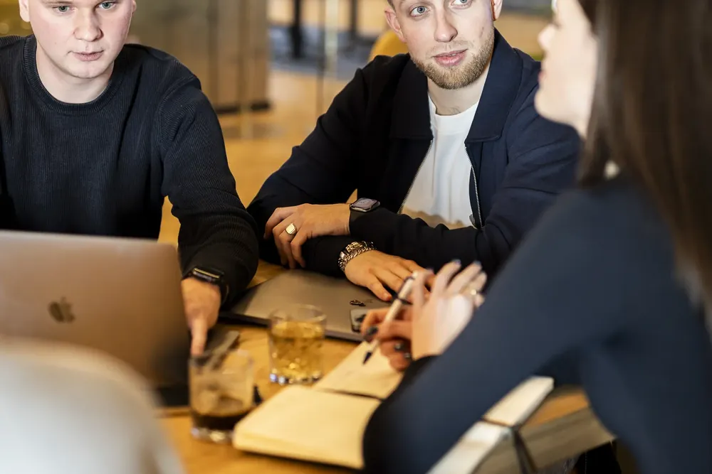 Collega's in overleg aan tafel met laptop en notitieboek