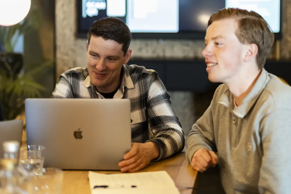 Twee collega's bekijken samen een beeldscherm