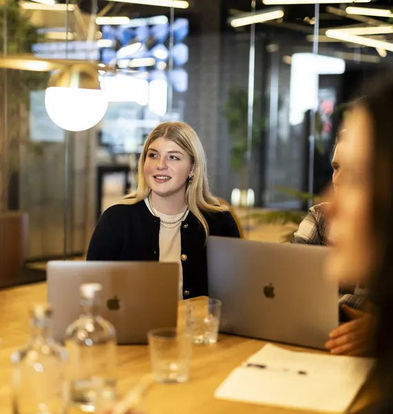 Collega aan tafel met laptops tijdens een gesprek