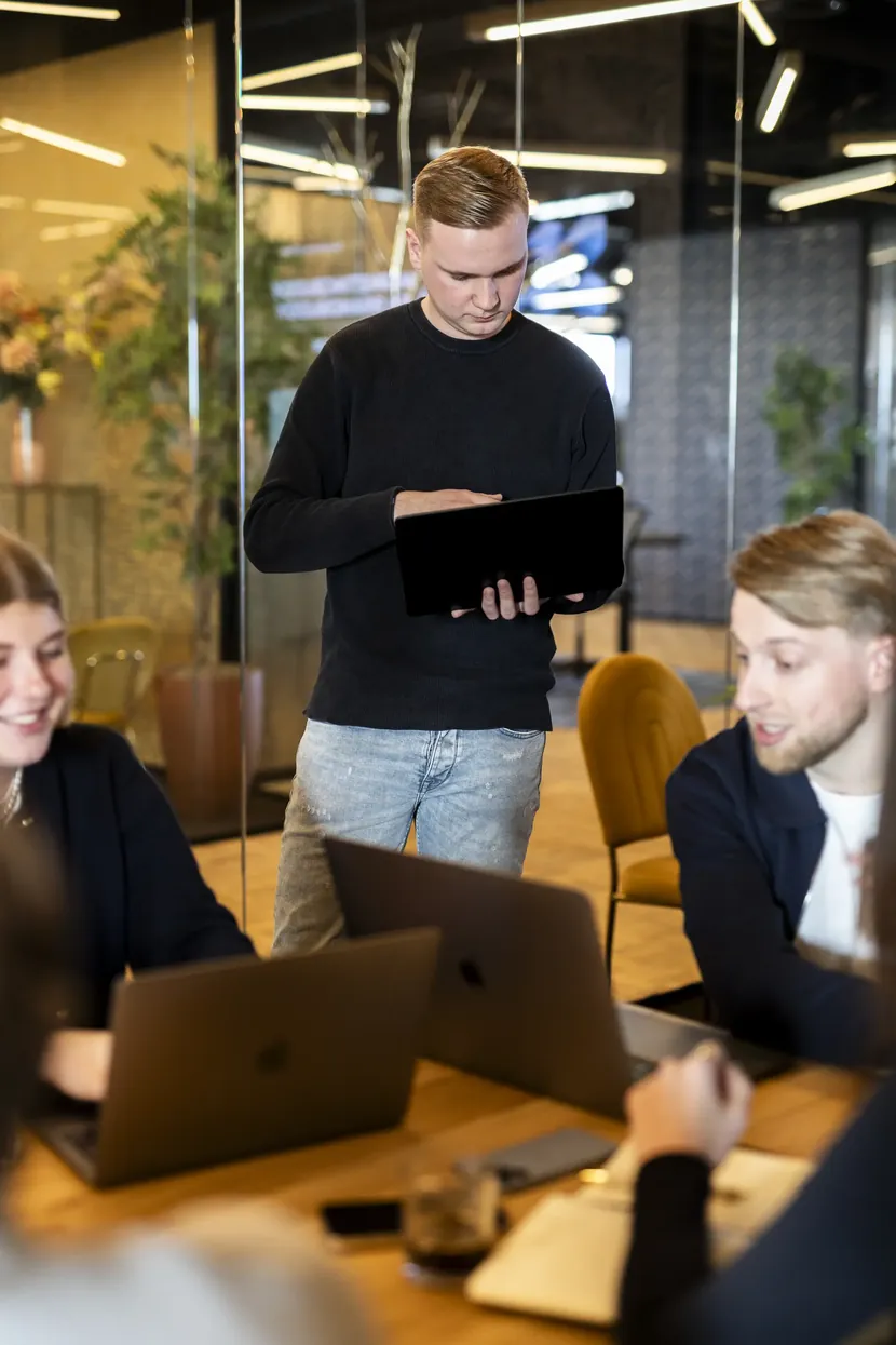 Collega presenteert met een tablet aan het team aan tafel