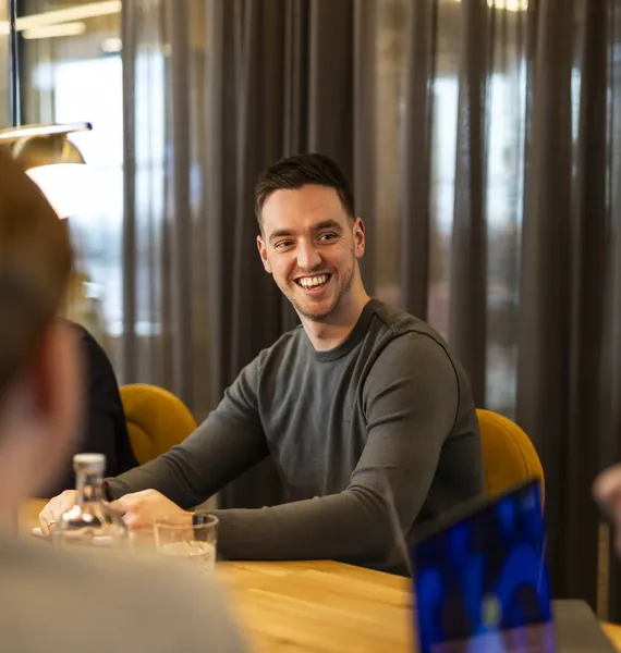 Collega lacht tijdens een overleg aan tafel