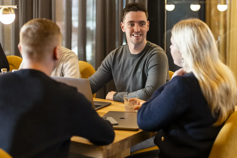 Collega's in overleg aan een vergadertafel met laptops