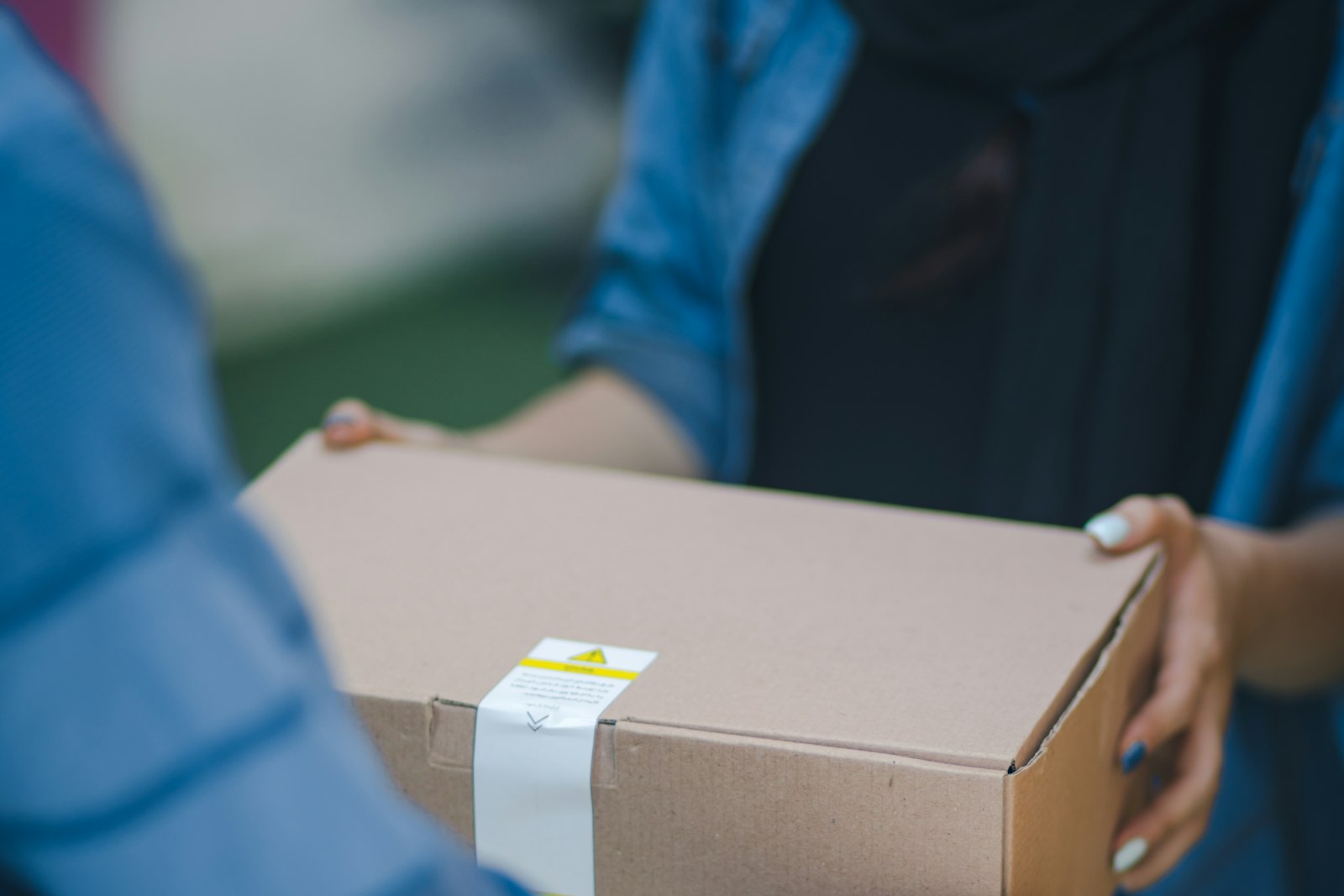 Een kartonnen pakket wordt overhandigd bij de bezorging